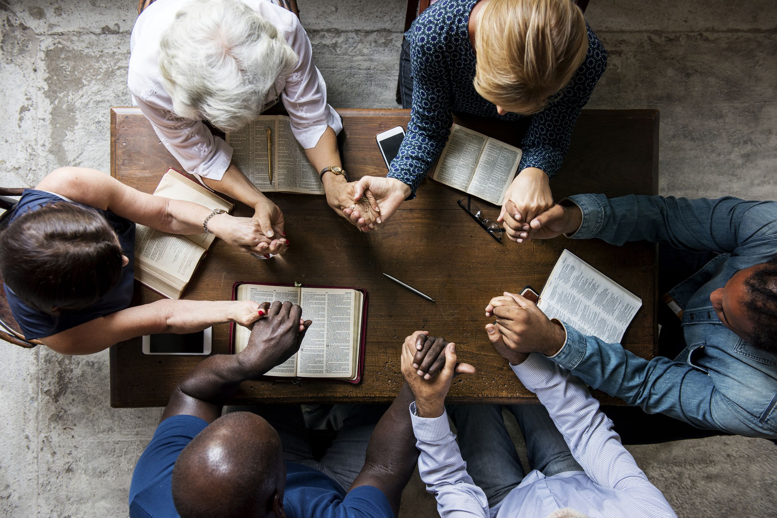 Group gathered around a table reading and studying together