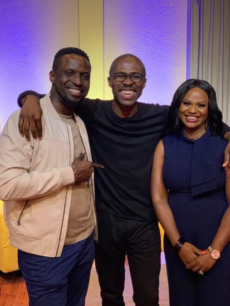 Three church members smiling together under purple and warm stage lighting