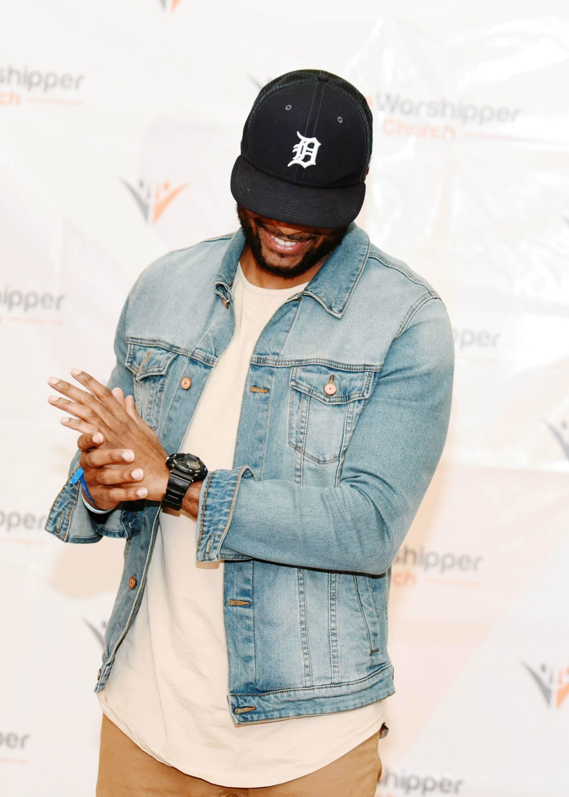 Man in denim jacket at church event backdrop
