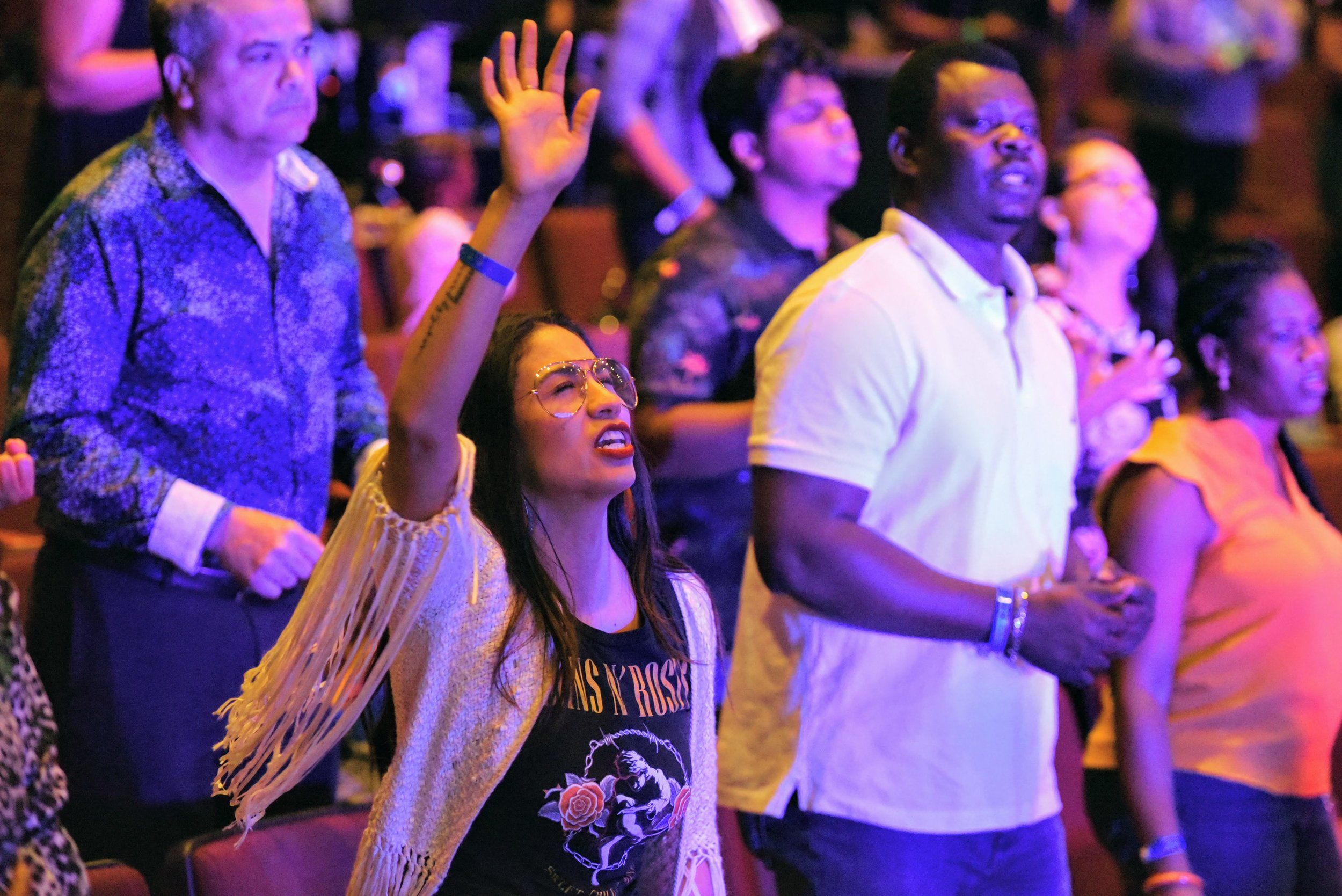 Woman worshipping with raised hands in the congregation