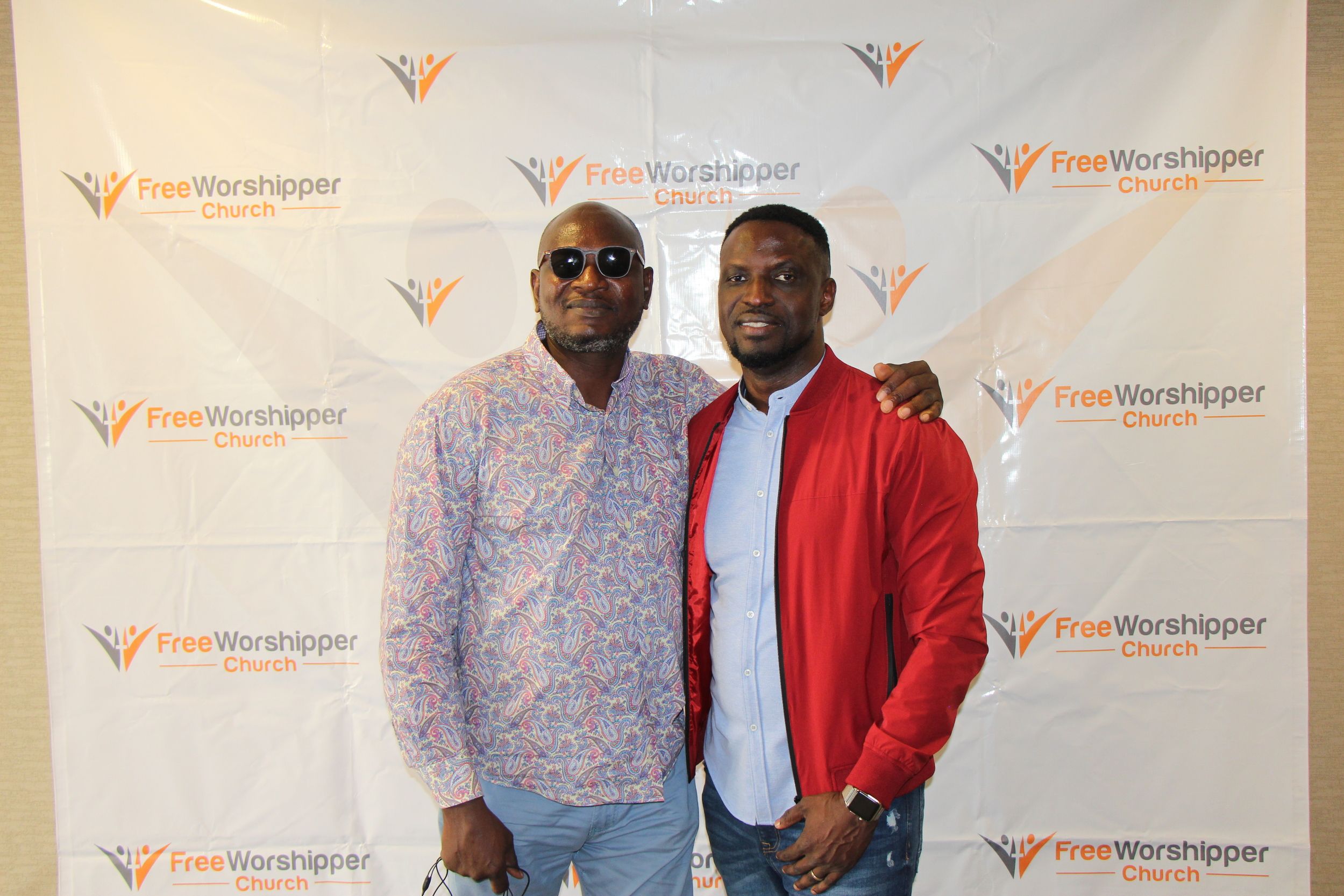 Two men posing together at a Free Worshipper Church event