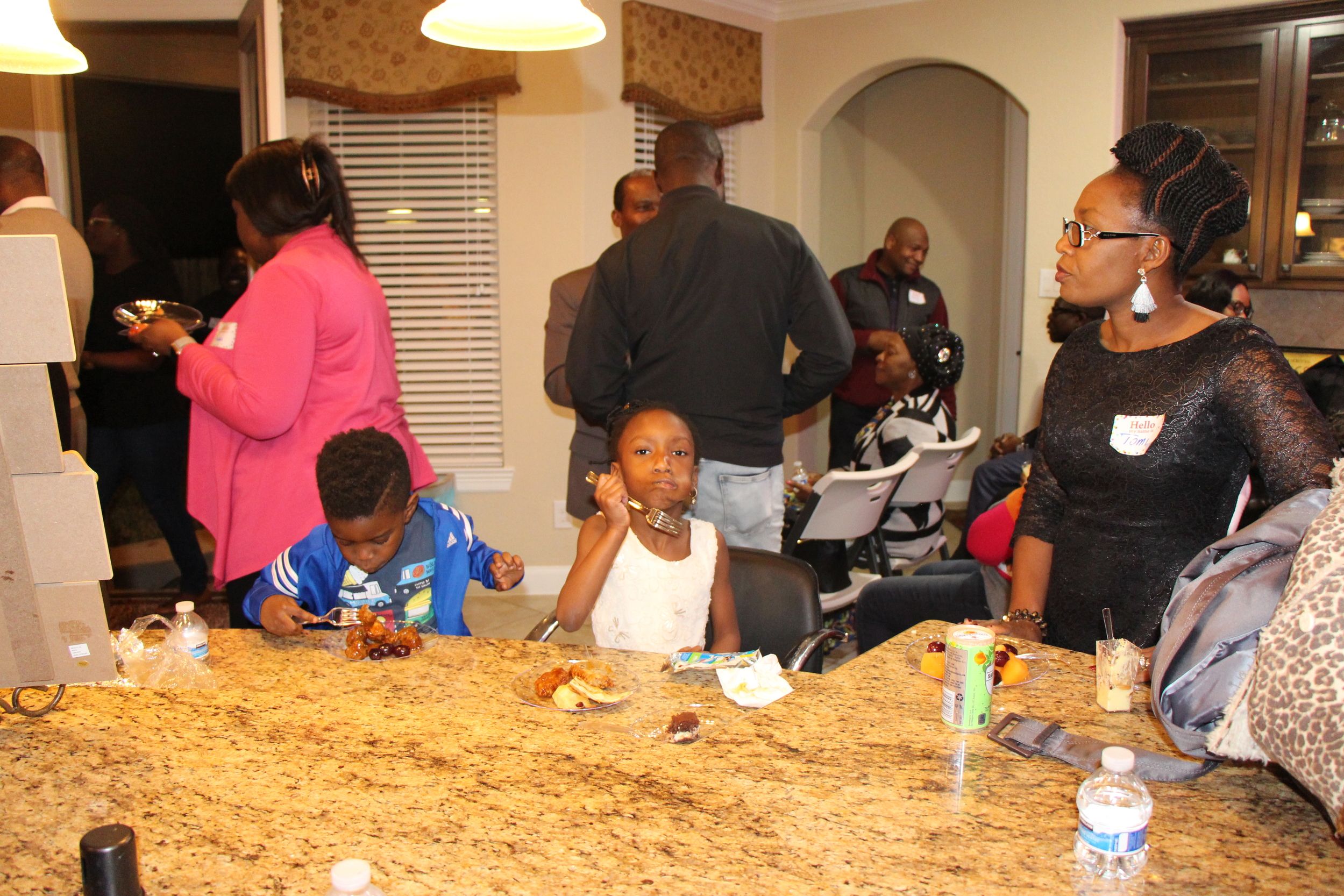Families and guests gathered around food during a church community event