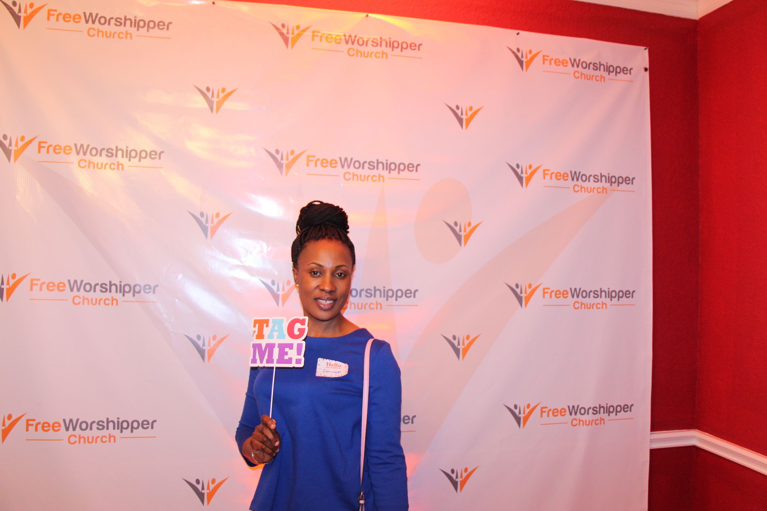Woman holding a Tag Me sign at a Free Worshipper Church event